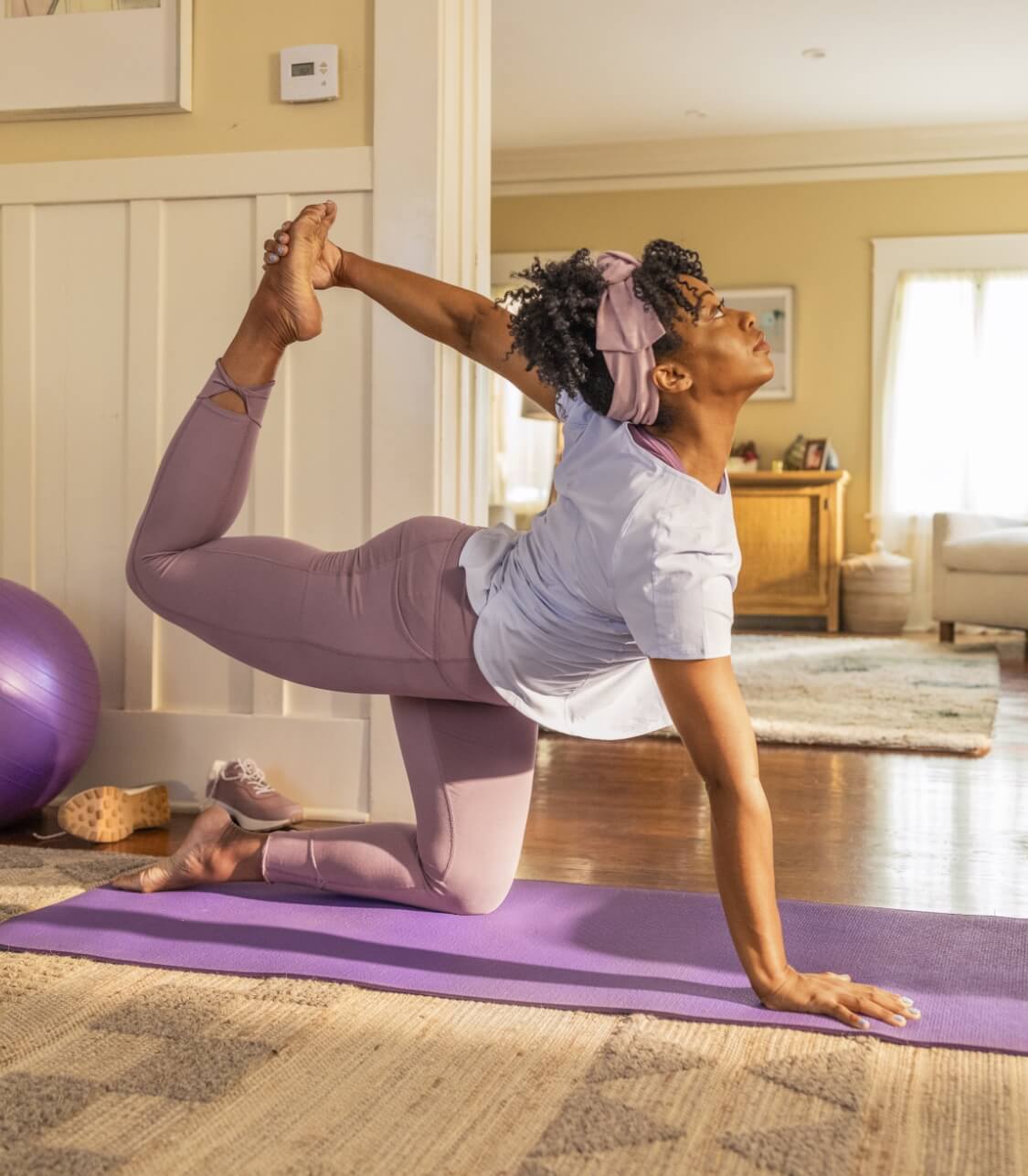 Actor portrayal of a woman who takes MYFEMBREE® (relugolix, estradiol, and norethindrone acetate) tablets doing yoga in her home 
